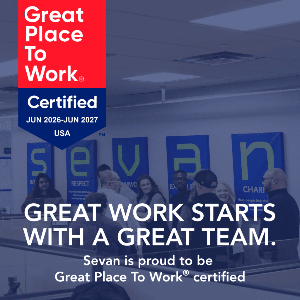 A group of people stand in an office under company value signs. Text highlights Sevan's Great Place To Work certification for June 2026–June 2027 in the USA.