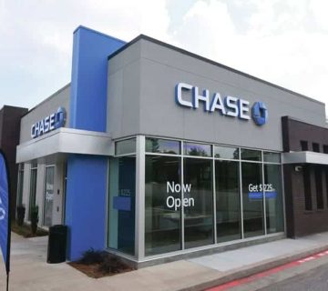 A Chase bank branch building with signage and banners reading "Now Open" and "Get $125," located next to a parking lot.