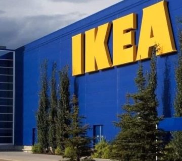 The exterior of an IKEA store with a large yellow logo on a blue building, surrounded by trees and a cloudy sky, highlights thoughtful construction and zoning in the area.