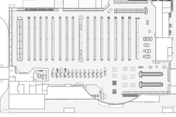 Black and white floor plan showing rows of seating, several rectangular tables, and multiple rooms along the perimeter of a large open area.
