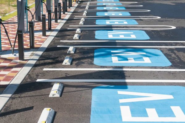 A row of empty electric vehicle charging stations with blue parking spots labeled "EV" in white letters.